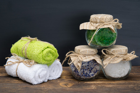 colored sea salt in jars on a table with towelsの写真素材