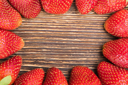 background beautiful strawberries lying around the board, in the middle of a place under an inscriptionの写真素材