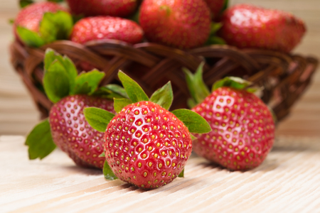 red strawberries from basket on a light tableの写真素材
