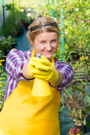 woman gardener sprays water on youの写真素材
