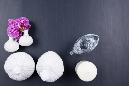black background with a set of massage with herbal bags and oil purple orchidの写真素材