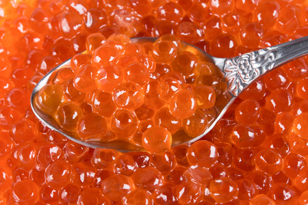 background with red caviar with a spoon in itの写真素材