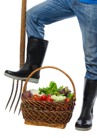 Basket with vegetables at the feet of a farmer isolatedの写真素材