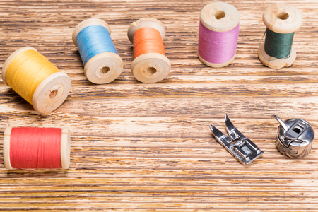 Wooden background with multi-colored threads on itの写真素材