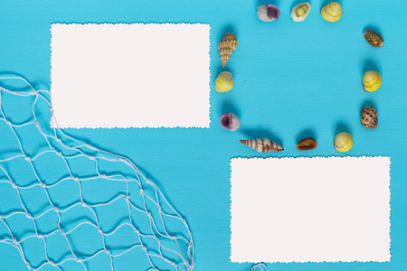 Circle of sea shells and paper on a blue backgroundの写真素材