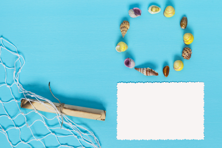 beautiful arrangement of seashells and paper on a blue backgroundの写真素材