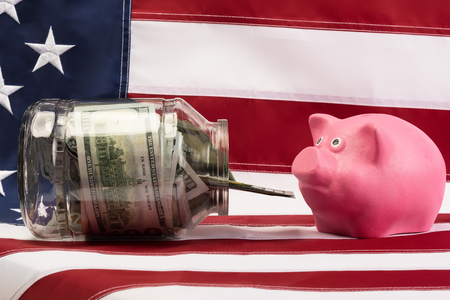 he bank with the money in front of a pink pig on the background of the USA flagの写真素材