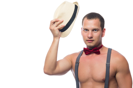 Sports man in suspenders takes off his hatの写真素材