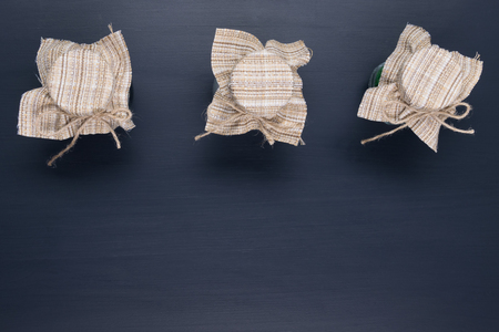 Three jars closed with a cloth on a black backgroundの写真素材