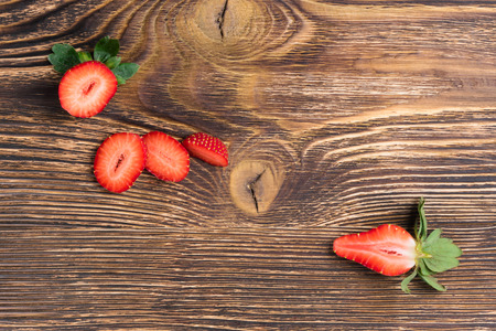 half a red strawberry on a dark desktop backgroundの写真素材