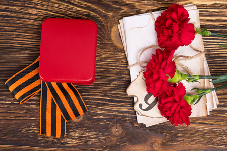 George's ribbon on the table with three carnations and lettersの写真素材