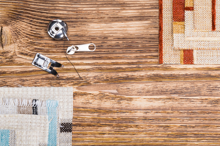Cloth and spare parts from a sewing machine on the tableの写真素材