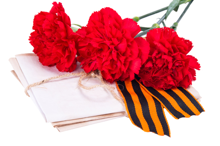 A stack of letters tied with a rope along with red carnations and ribbon to the day of victory, on a white backgroundの写真素材