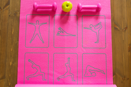 Pink gymnastic mat and dumbbells on the floorの写真素材