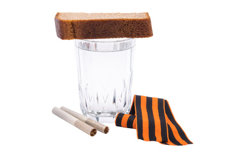 George ribbon lies under a glass of vodka, isolated on white backgroundの写真素材