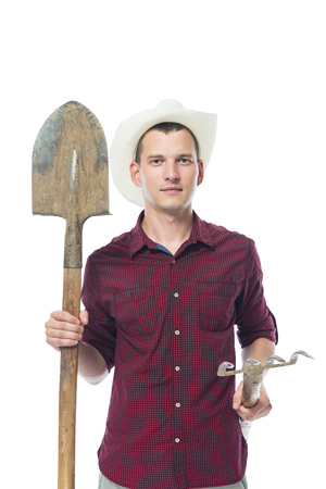 farmer in the shirt holds the tool for soil processingの写真素材