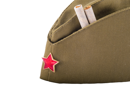 Two cigarettes inserted into a military head-dress in honor of May 9, in front of a white backgroundの写真素材