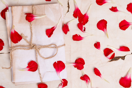 Envelopes on old paper are covered with flower petalsの写真素材