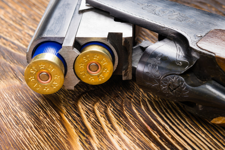 Two bullets in a gun on an old wooden backgroundの写真素材