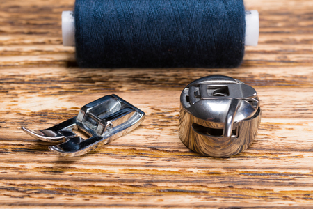 Shuttle from the sewing machine and paw on the tableの写真素材