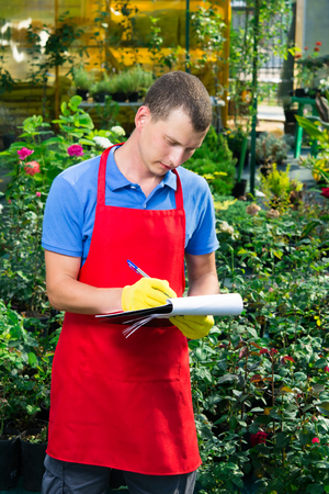 The man keeps a register of plants in the gardenの写真素材