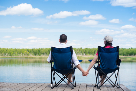 pair of lovers sit on the pier and look at natureの写真素材