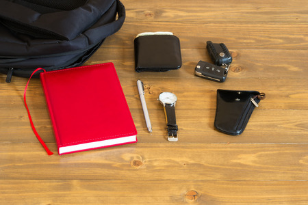 Things from a men's bag lie on a dark wooden backgroundの写真素材