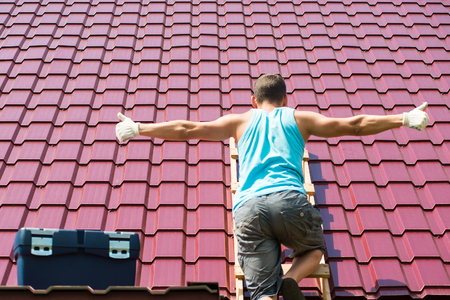 The man spread his hands for the inscription on the roof backgroundの写真素材