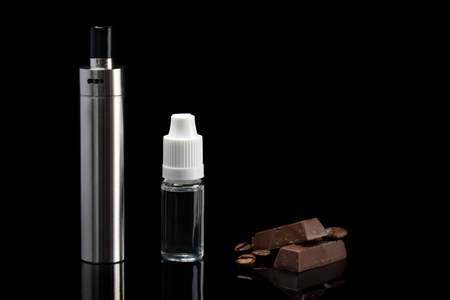 Concept of electronic cigarette and aroma of chocolate with a coffee, on a black background with reflectionの写真素材