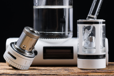 Process of filling an electronic cigarette with liquid, on the desktopの写真素材