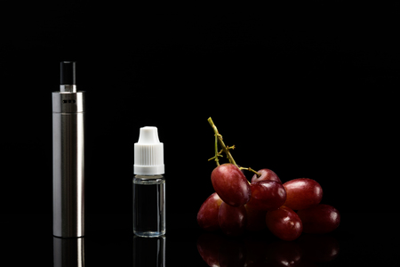 Electronic cigarette with grape flavor, concept on a black backgroundの写真素材