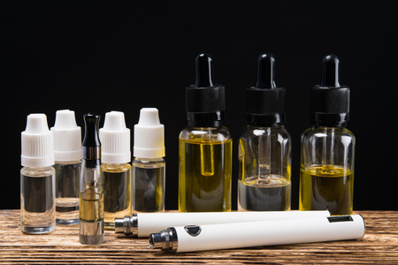 Electronic cigarette on a background of six bubbles with fluids of different flavorsの写真素材