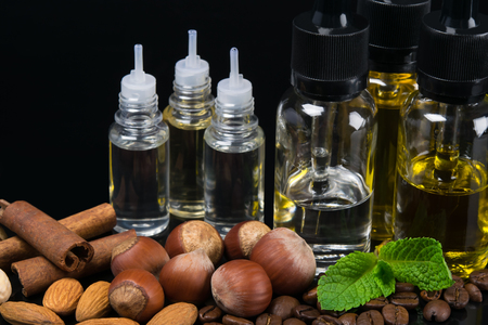 Aromas of nuts and mint mixed in bottles, concept on a black backgroundの写真素材