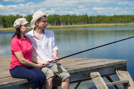 Husband and wife fishing on the lake from the pierの写真素材