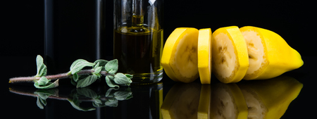 Liquid with banana flavor next to a fragrant green sprout, on a black backgroundの写真素材