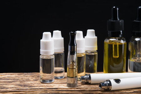 vaping set and liquid with aromas on a dark backgroundの写真素材