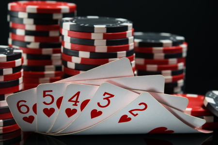 Straight flush against a black background, behind a big bet on winningの写真素材