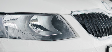 washing a car headlight lighting the foam close-up