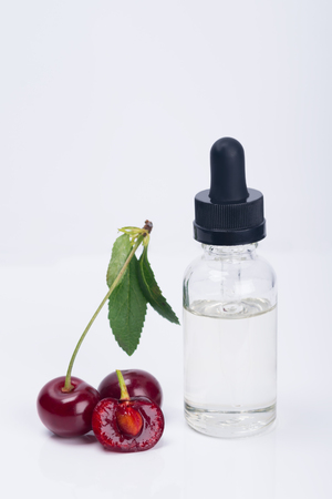 aroma and flavor enhancer next to a ripe cherry, on a white backgroundの写真素材