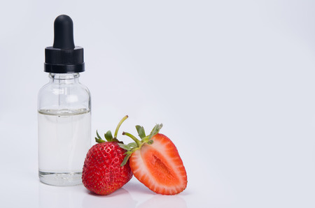 aroma and flavor enhancer next to ripe strawberries, on white backgroundの写真素材
