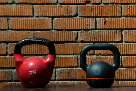 two different dumbbells against the backdrop of a brick wall in the gymの写真素材