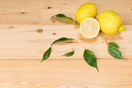 beautiful lemons with green branches on a wooden backgroundの写真素材