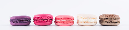cakes of different colors lie in a row, on a white background