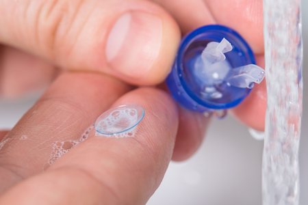 right container for eye lenses in the hands of the bathroomの写真素材