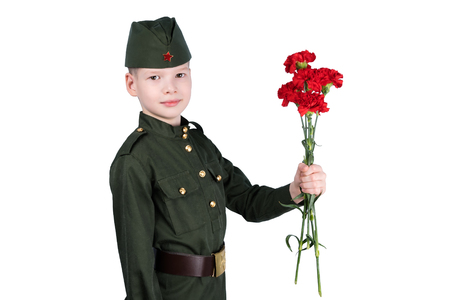 boy in military uniform holds a bouquet of red flowers in hands, isolated on white backgroundの写真素材