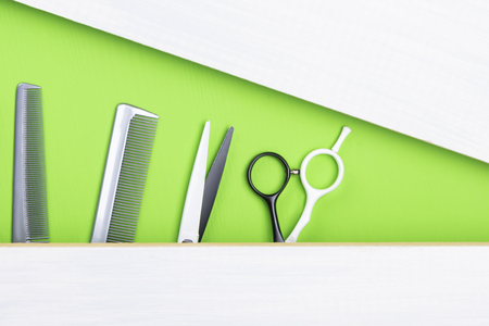 idea of a green and gray background with a comb and scissors for a hairdresserの写真素材