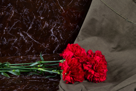 4 carnations with a military cloth, on the background of a memorial plateの写真素材