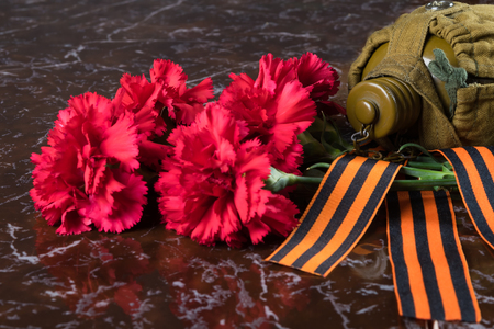 red bouquet of flowers with a military jar and festive ribbons, on the background of marbleの写真素材