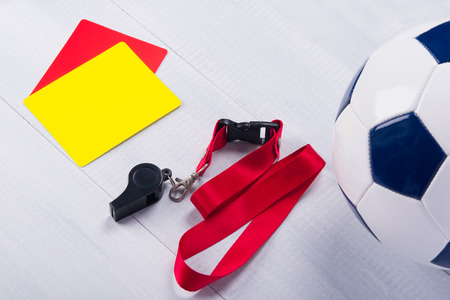 Football ball, two penalty cards and a whistle for the referee, on a gray backgroundの写真素材