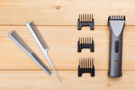 two combs with attachments for electric cars, for hair cutting, on wooden boardsの写真素材